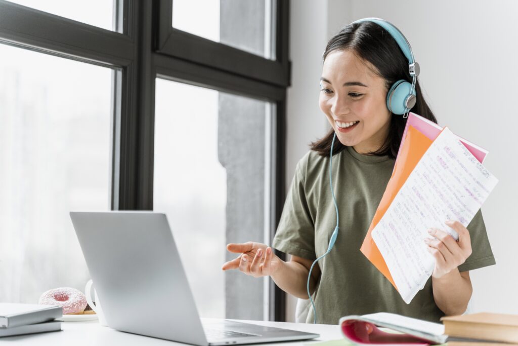 woman with headphones having video call laptop